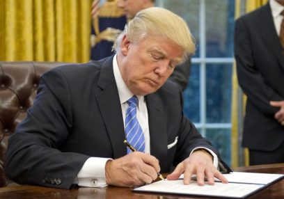 WASHINGTON, DC - JANUARY 23:  (AFP OUT) U.S. President Donald Trump signs the last of three Executive Orders in the Oval Office of the White House in Washington, DC on Monday, January 23, 2017.  These concerned the withdrawal of the United States from the Trans-Pacific Partnership (TPP), a US Government hiring freeze for all departments but the military, and "Mexico City" which bans federal funding of abortions overseas. (Photo by Ron Sachs - Pool/Getty Images) 694681111